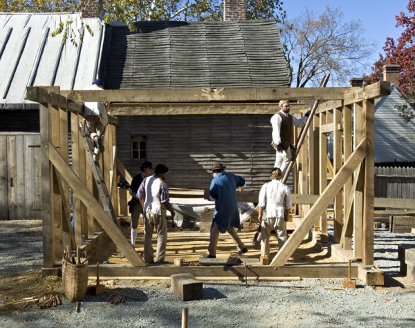 The Historic Trades Carpenters carry in one of the ceiling joists during the Anderson Kitchen frame-raising. Photo by Willie Graham.