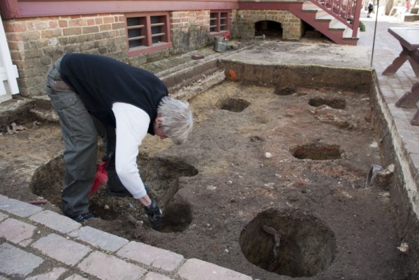 Staff Archaeologist Andrew Edwards excavating postholes in front of the tavern. 