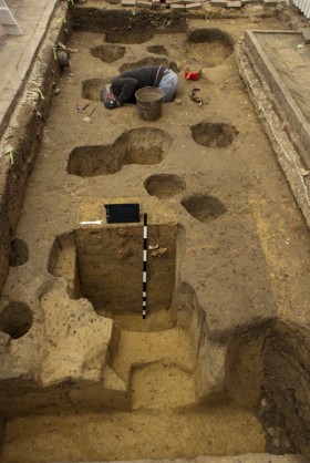 One of the postholes half-excavated. If you look at the top of the feature, can you see the color difference between the posthole fill and the surrounding soil? 