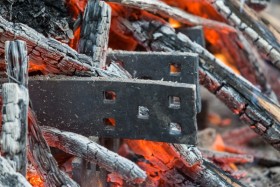 The metal rims -- or strakes -- for the carriage wheel are heated in an open fire before being placed on the wooden wheel.