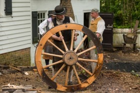 Journeyman wheelwright Andrew De Lisle examines the metal rims on an18th-century gun-carriage wheel. 