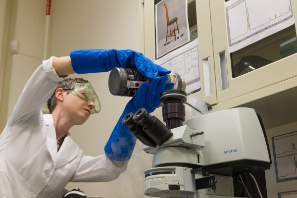 Materials Analysis lab for a Conservation blog. Kirstin Moffitt with the “FTIR microspectrometer demonstrates how we use it to ID materials.” To prep the instrument, liquid Nitrogen is poured into the detector to cool it to it's working temperature. MODEL RELEASED