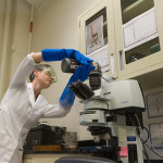 Materials Analysis lab for a Conservation blog. Kirstin Moffitt with the “FTIR microspectrometer demonstrates how we use it to ID materials.” To prep the instrument, liquid Nitrogen is poured into the detector to cool it to it's working temperature.  MODEL RELEASED