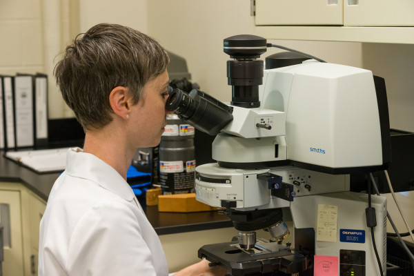 Materials Analysis lab for a Conservation blog. Kirstin Moffitt with the “FTIR microspectrometer demonstrates how we use it to ID materials.” To prep the instrument, liquid Nitrogen is poured into the detector to cool it to it's working temperature. MODEL RELEASED