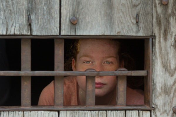 Emily Sullivan peers through a barred window at the Public Gaol.