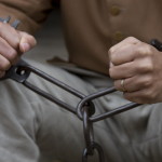 An enslaved person in shackles.