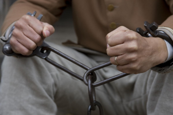 An enslaved person in shackles.