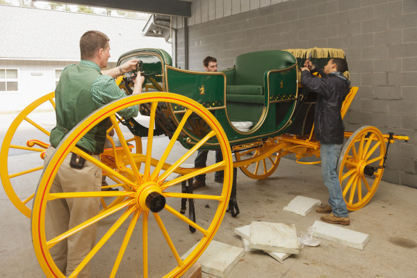 Paul Bennett (L) is assisted in assembly of the new sociable body for the Randolph Coach.