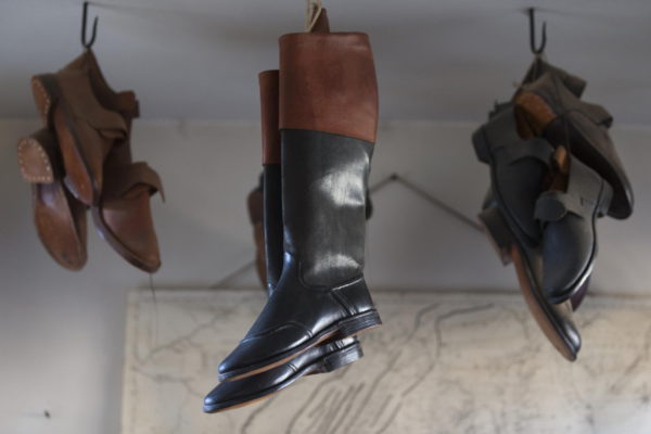 Shoes and boots hang rom the ceiling at the Shoemaker shop