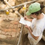 Archaeologist Brittany Higgs records a preserved patch of 18th-century brick paving along Duke of Gloucester Street at the Raleigh Tavern.