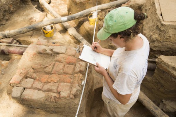 Archaeologist Brittany Higgs records a preserved patch of 18th-century brick paving along Duke of Gloucester Street at the Raleigh Tavern.